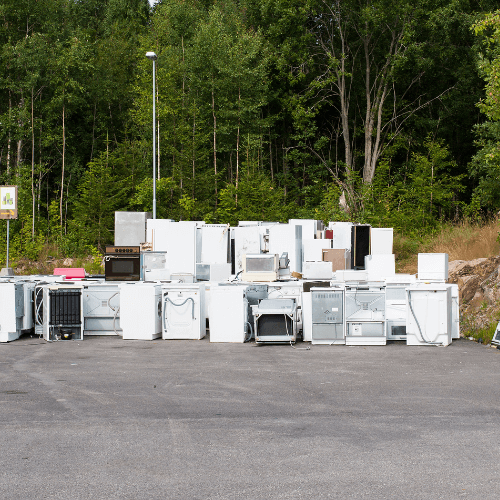 Household appliances stacked in a lot for removal from Big Body Bros, appliance removal services.